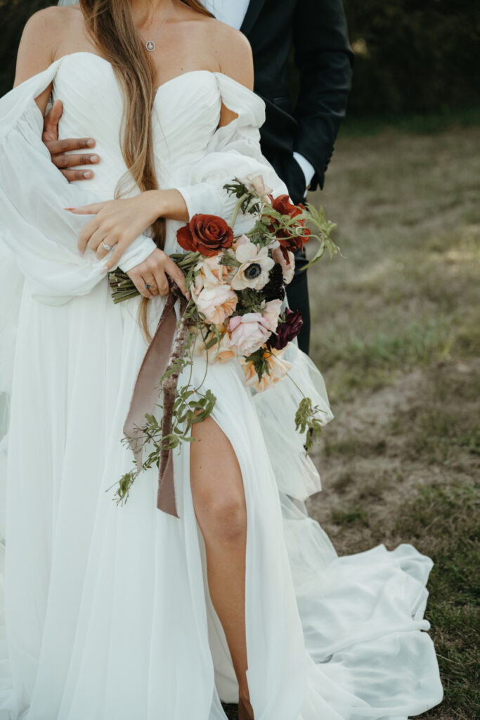 A barefoot bride in a flowing gown with her groom in a classic tux.