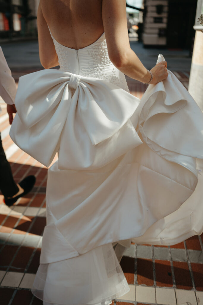 bow onto the back of a wedding dress