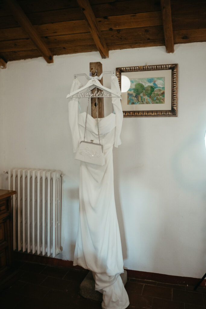 bride dress hanging up at castello di ristonchi wedding 