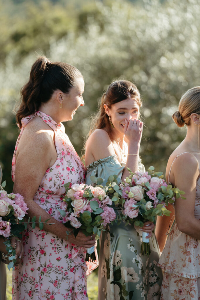 A bridesmaid giggles through happy tears during the ceremony, a moment that shows why you should choose the perfect wedding photographer to capture every emotion.