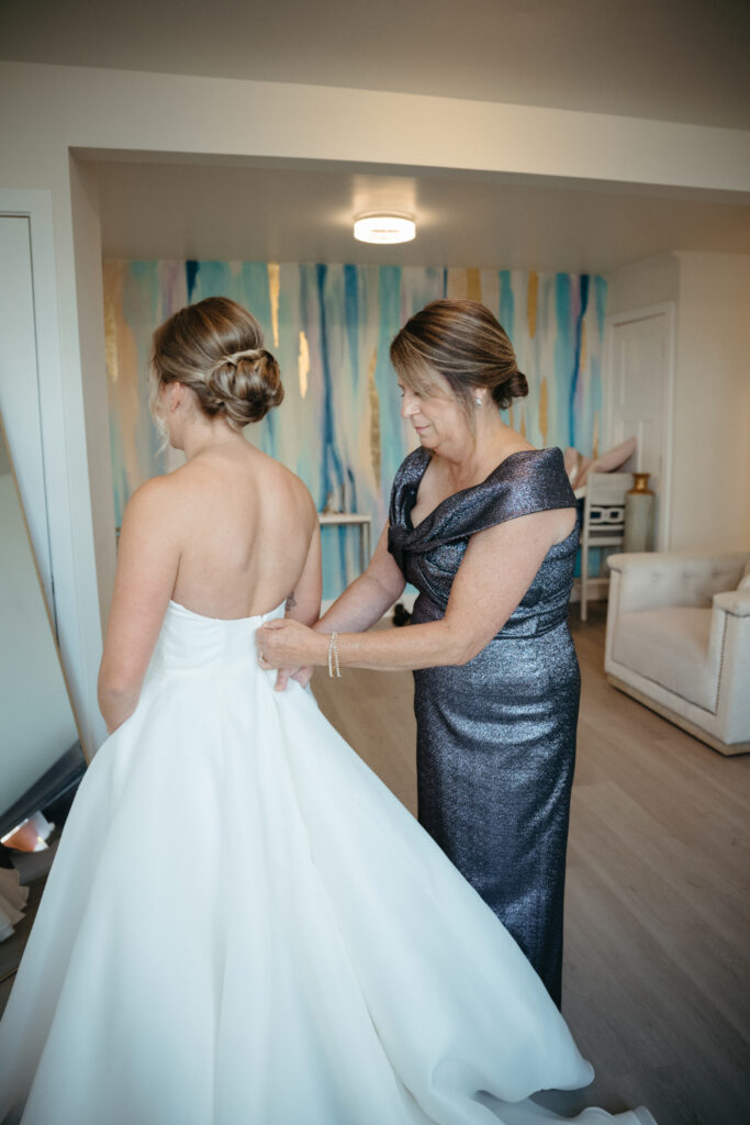 brides mother zipping up dress