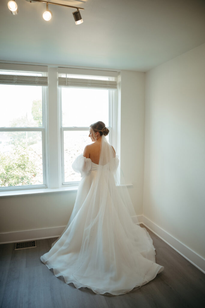 bride facing away from the camera with wedding dress and veil on