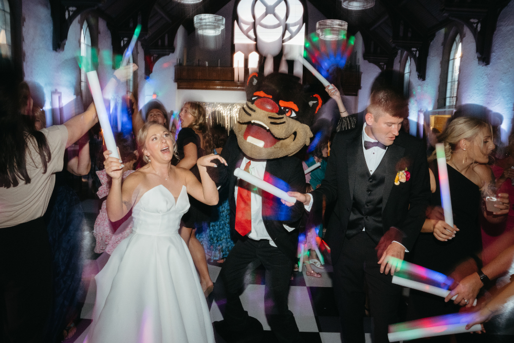 bride and groom with their wedding guests and UC Bearcat mascot dancing during their reception at the palomar cincinnati