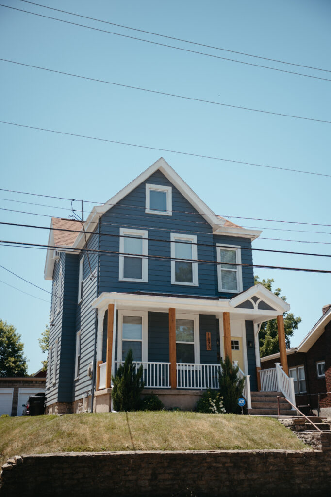 A blue house with white trim and a front porch.