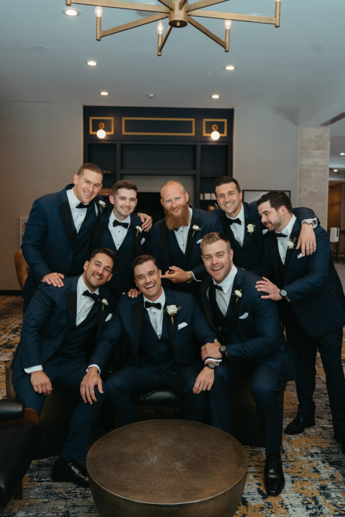 Groomsmen posing together in a lounge.