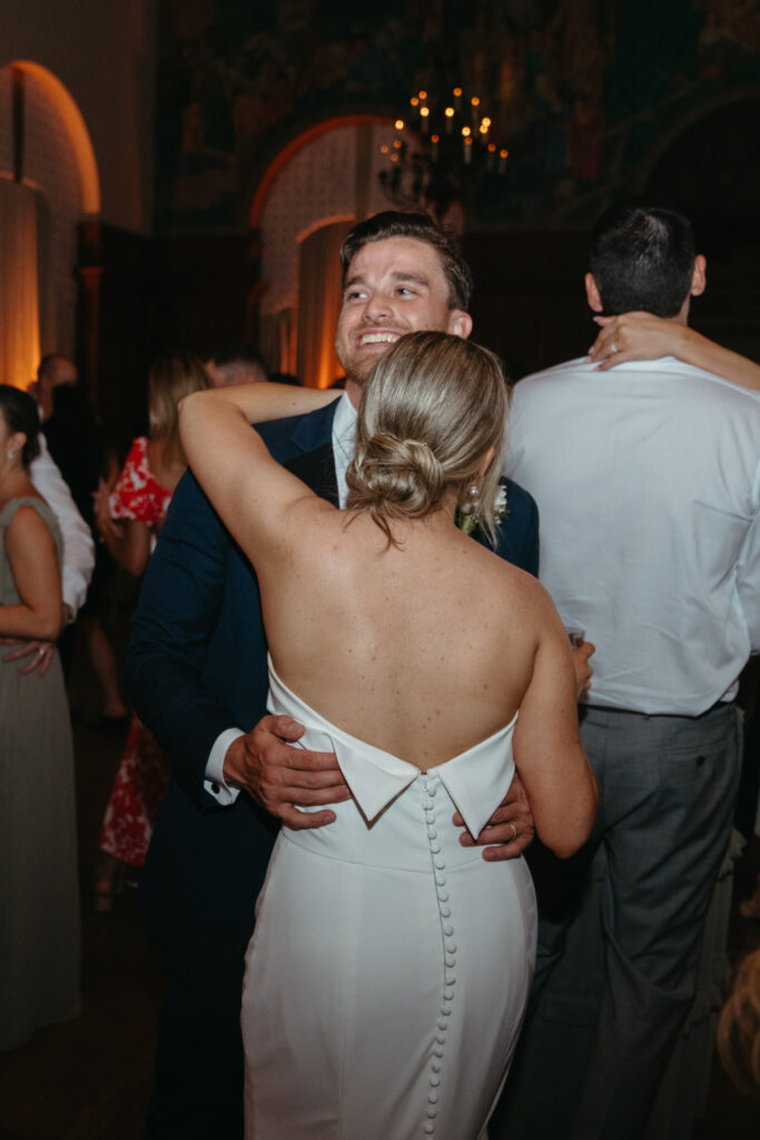 bride and groom dance at cincinnati club wedding reception with guests