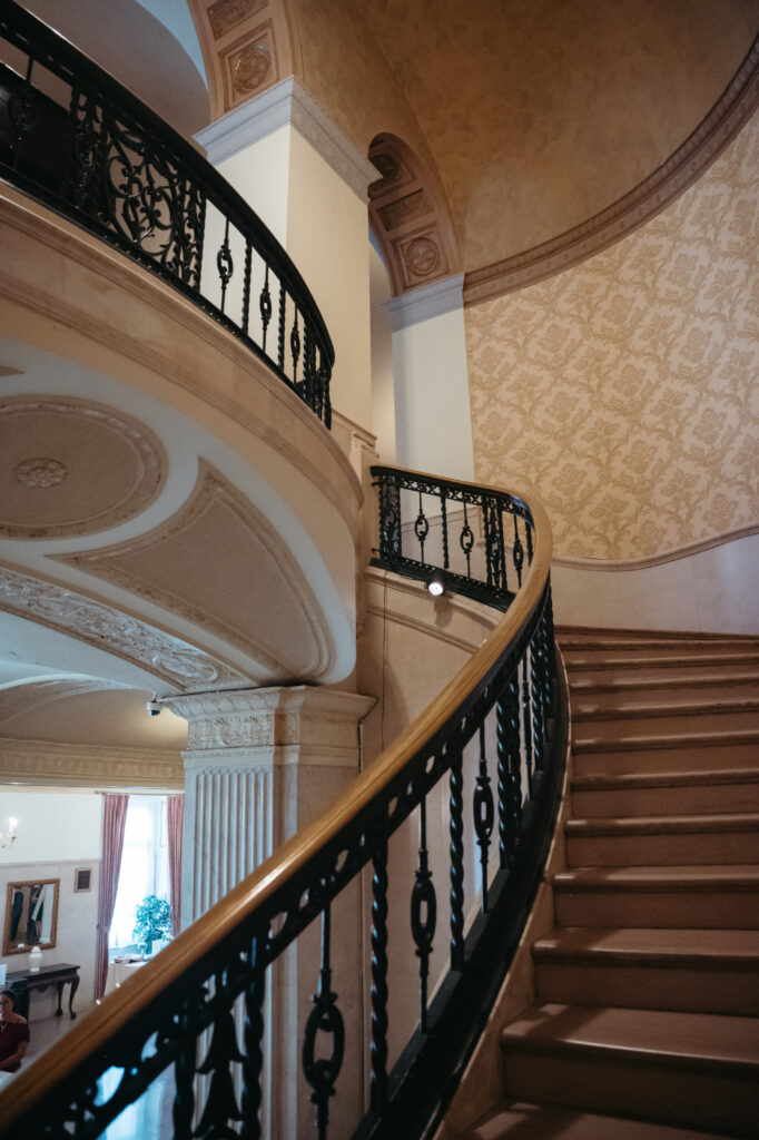 Curved staircase with ornate railing inside the venue.
