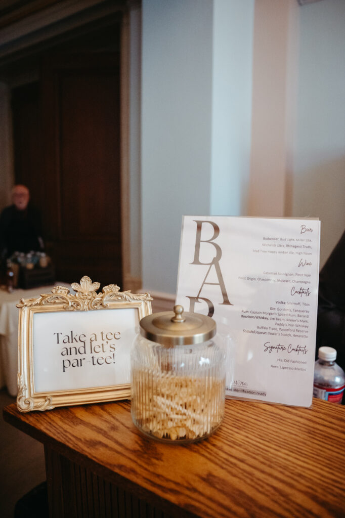 Bar setup with a sign reading "Take a tee and let’s par-tee!"
