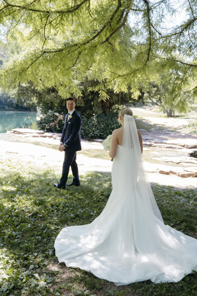 Bride approaching groom for first look by a pond.
Bride approaching groom for first look by a pond.
