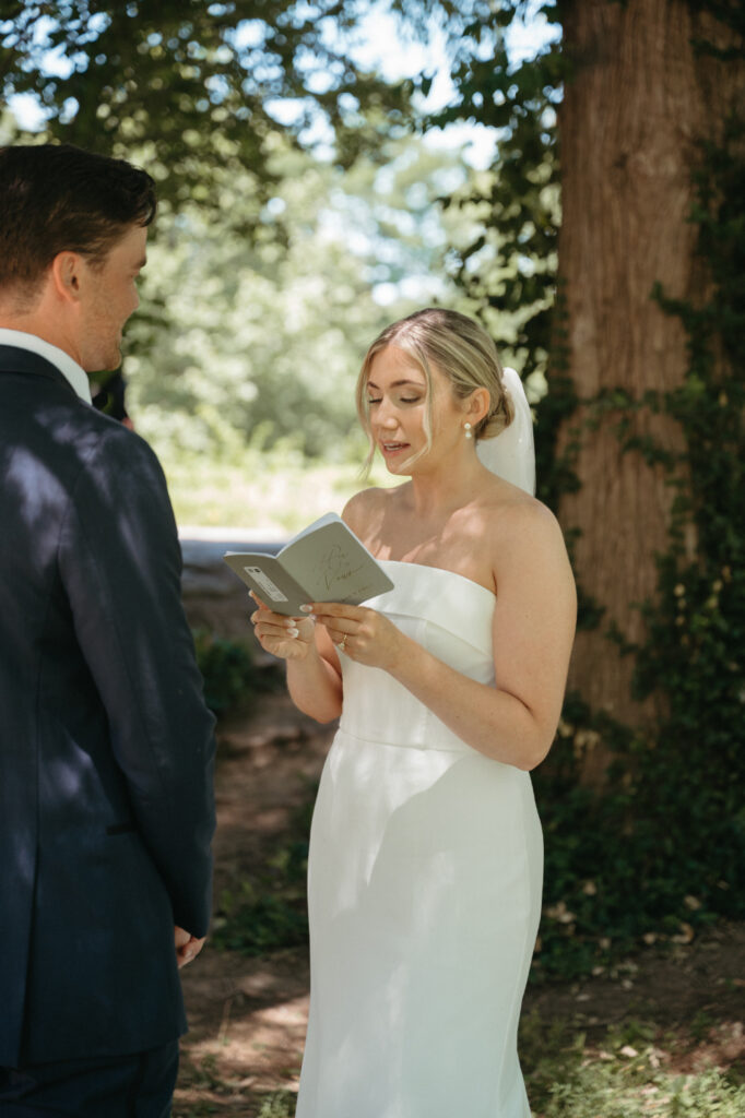 Bride reading vows to groom.
