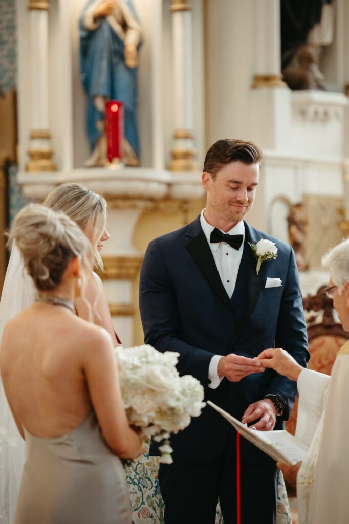 Groom takes the wedding ring from the priest