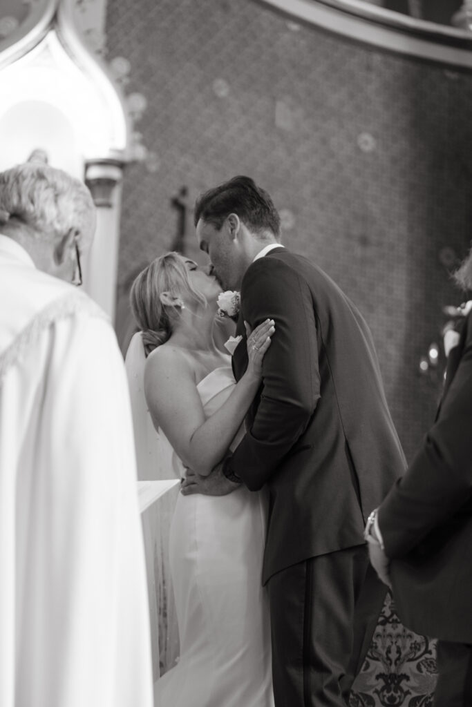 Bride and groom share their first kiss at the altar.
