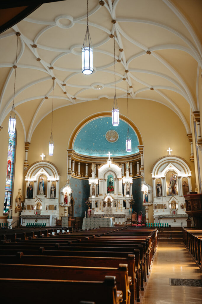 Ornate church altar at St. Rose Catholic Church with statues, candles, and a blue dome ceiling with gold stars.
