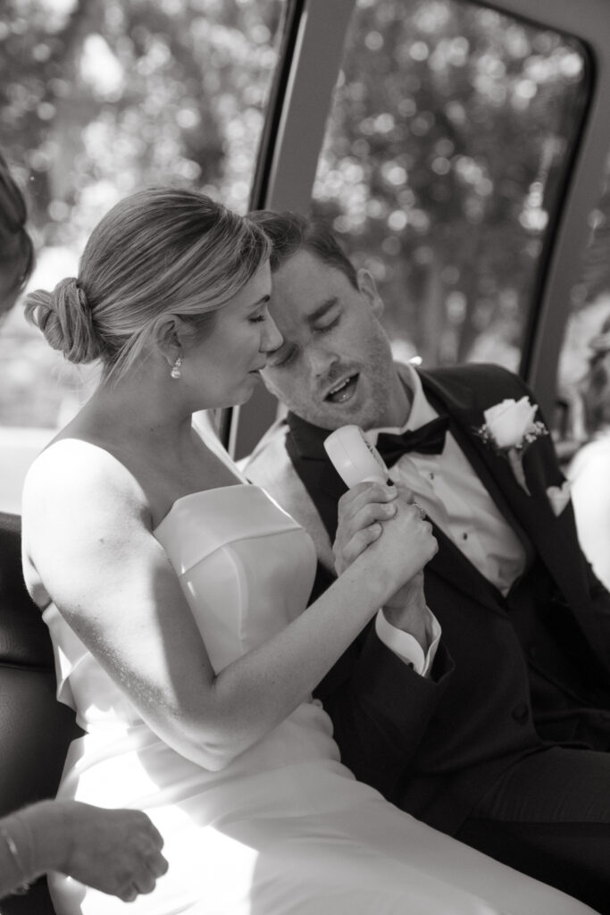 Bride and groom singing together in the party bus.
