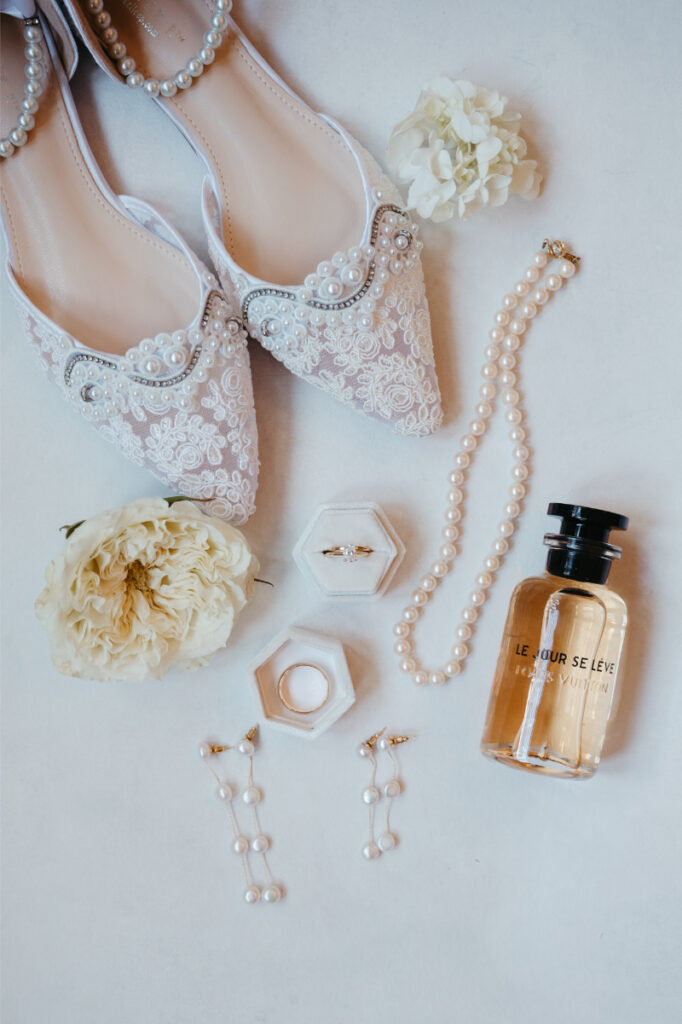 white wedding shoes and perfume flatlay