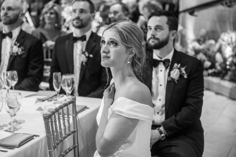 black and white photo of bride watching toasts