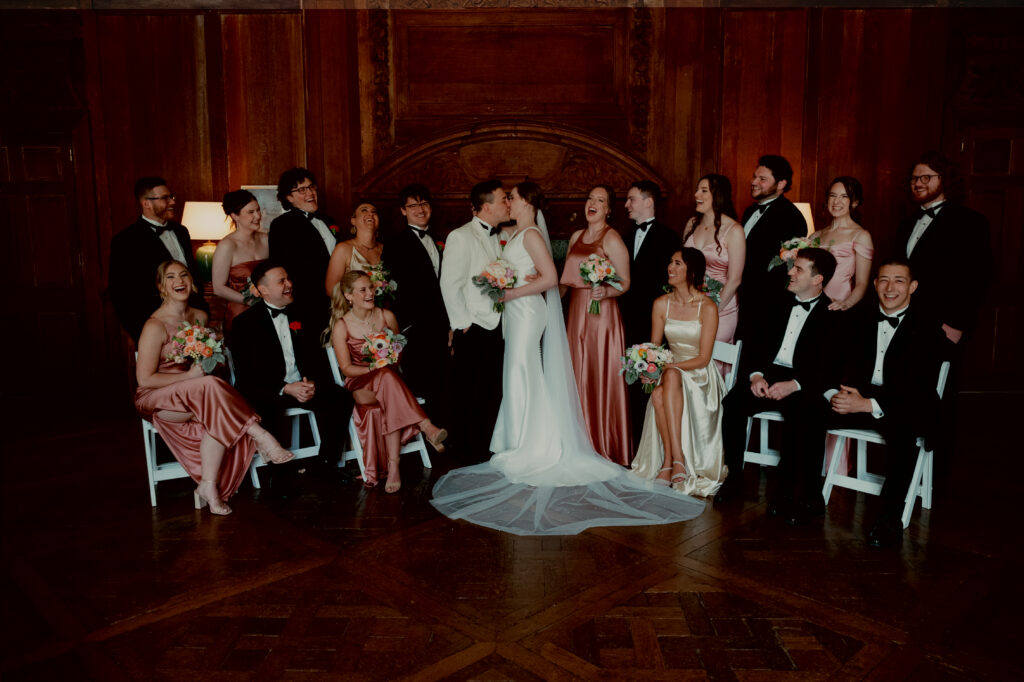 real-wedding-feature bride and groom kissing and their wedding party cheering them on
