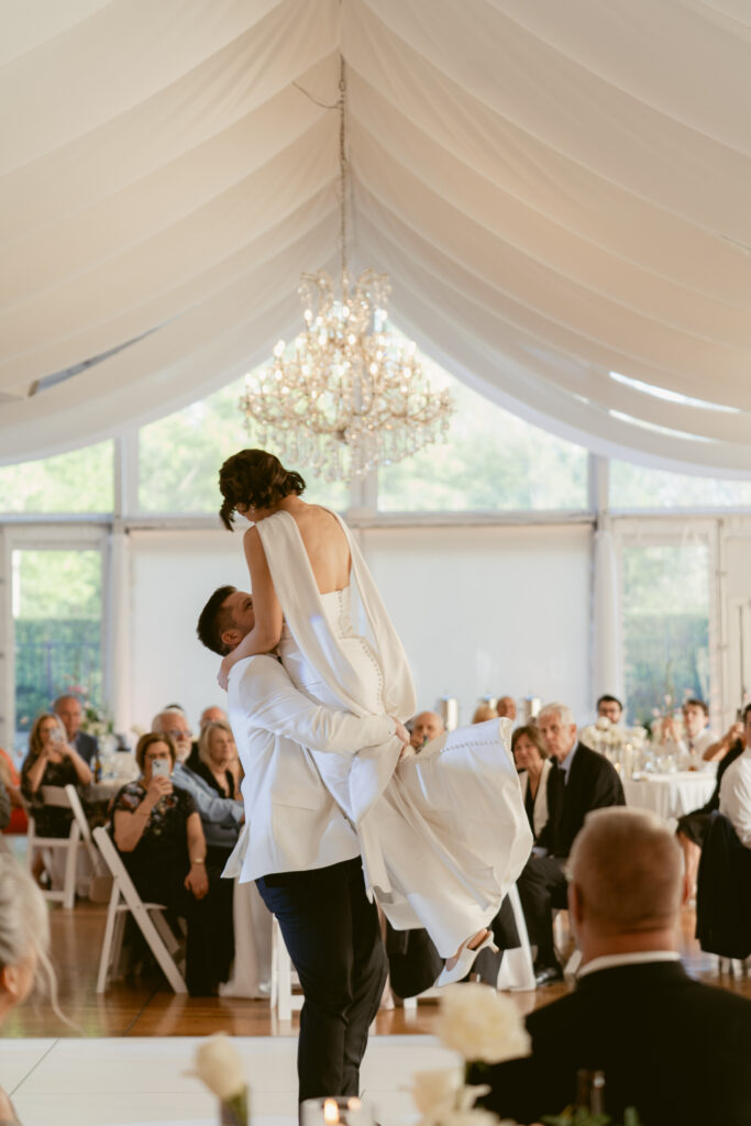 The newlyweds share an unforgettable first dance beneath the elegant tent at Pinecroft at Crosley Estate.