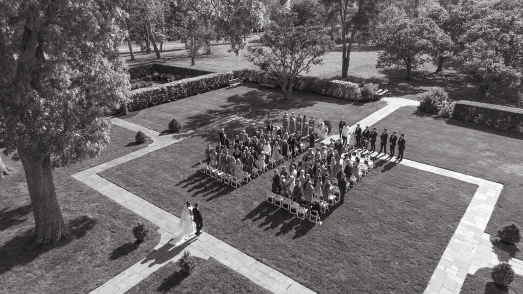 A stunning black and white aerial view captures the bride’s walk down the aisle at Pinecroft.