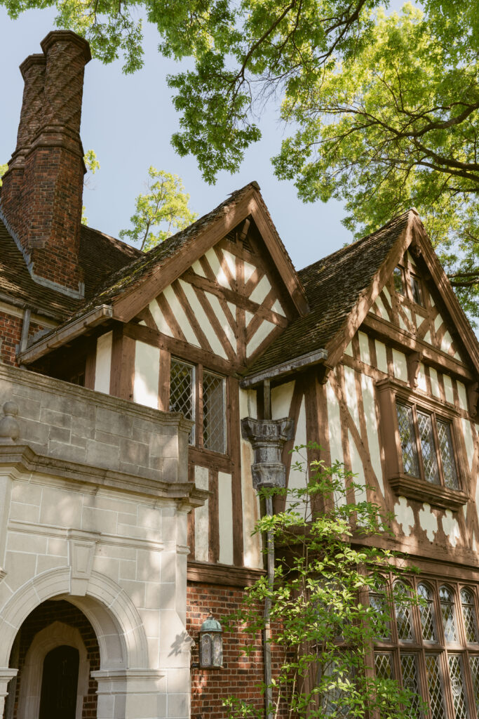 Sunlight filters through trees onto Pinecroft at Crosley Estate’s charming Tudor-style architecture and leaded windows.