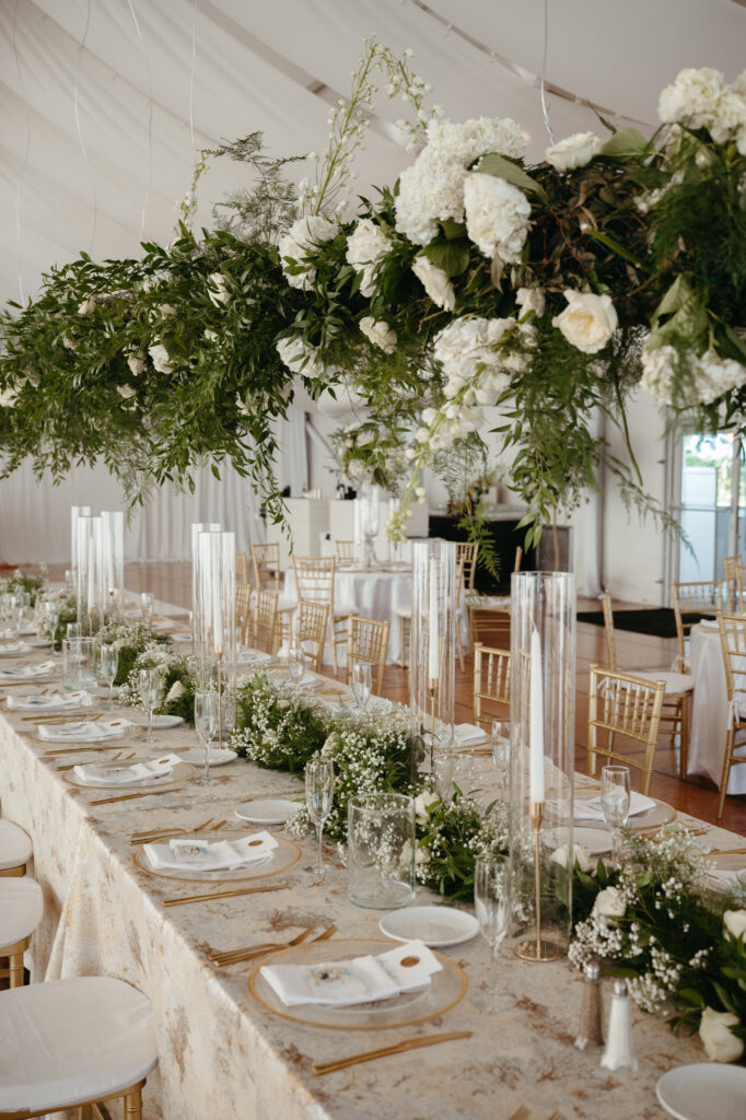 wedding-color-palette Elegant wedding color palette features lush greenery, white florals, and gold accents on a lavish table.