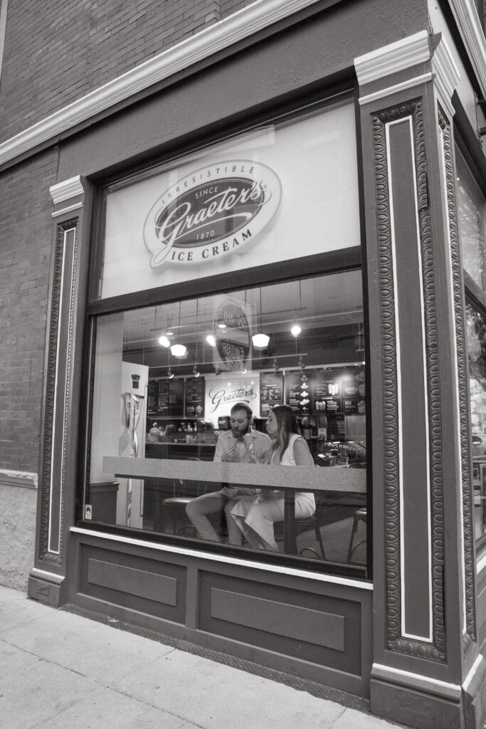 engagement-photo-tips Couple sitting inside Graeter’s Ice Cream shop in Cincinnati, enjoying ice cream together during their engagement session, captured as part of creative engagement photo tips.