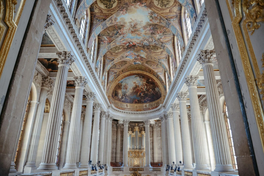 Ornate European chapel with tall white columns, golden details, and a painted ceiling—perfect for couples dreaming of getting married in Italy.