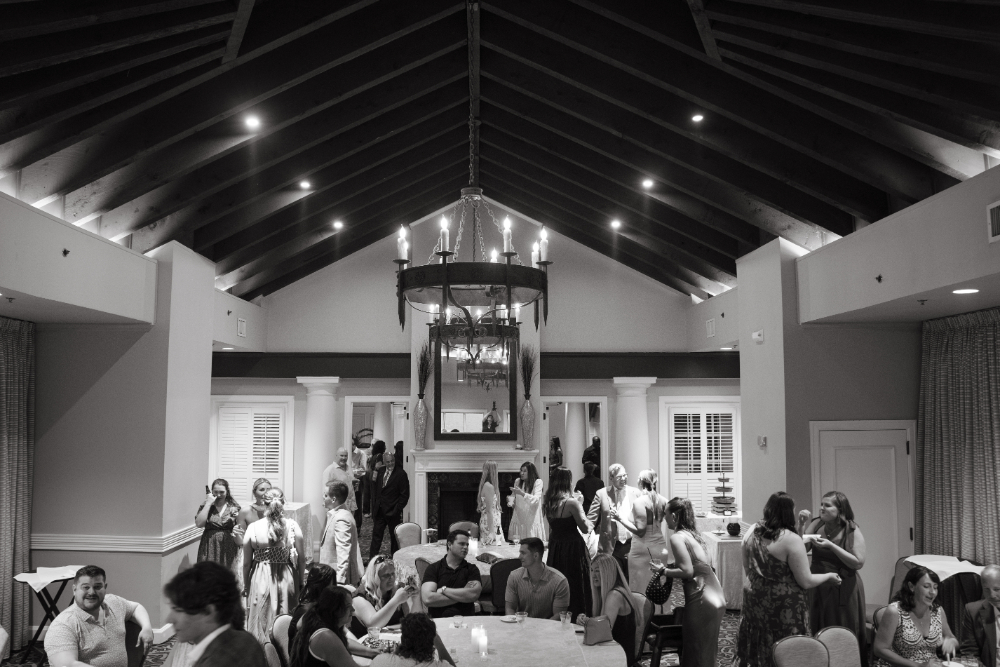 Guests mingle and chat inside the Retreat Room at The King and Prince Resort during the rehearsal dinner.