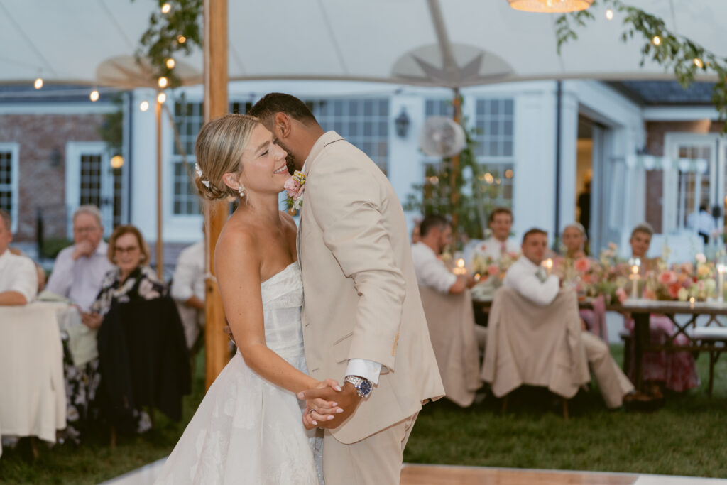 man and woman hold each other close during their first dance as husband and wife