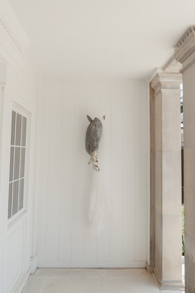 Bridal veil and shoes hanging on a horse sculpture, captured by top Cincinnati wedding photographers.
