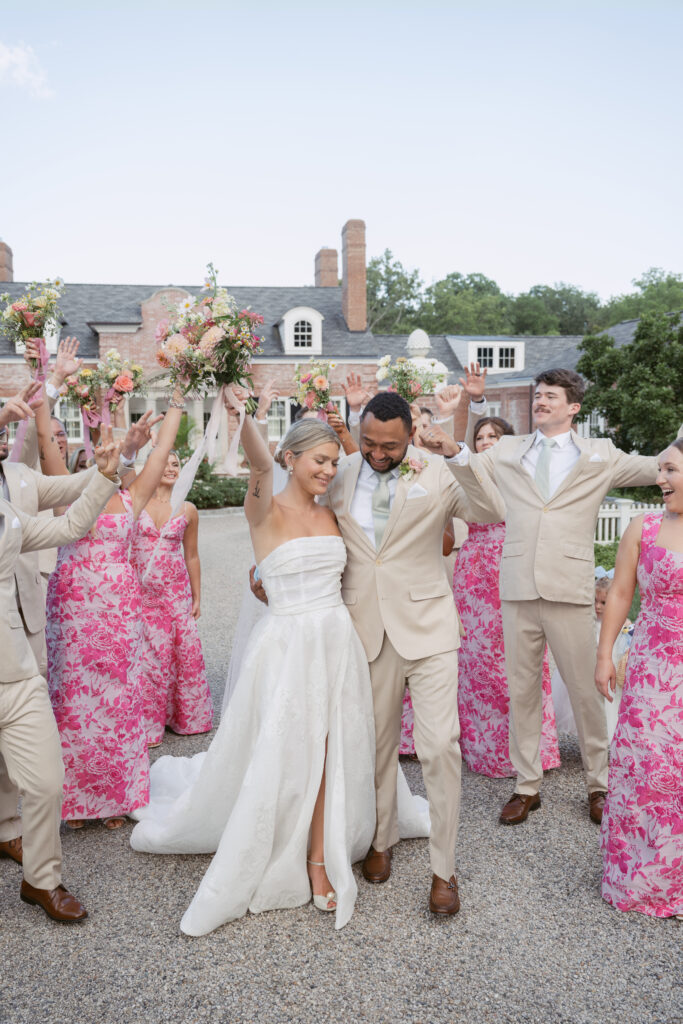 bride and groom surrounded by their wedding party celebrating being just married