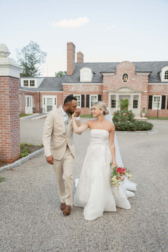 groom bringing his wife's hand up for a kiss at a wedding at meshawa house