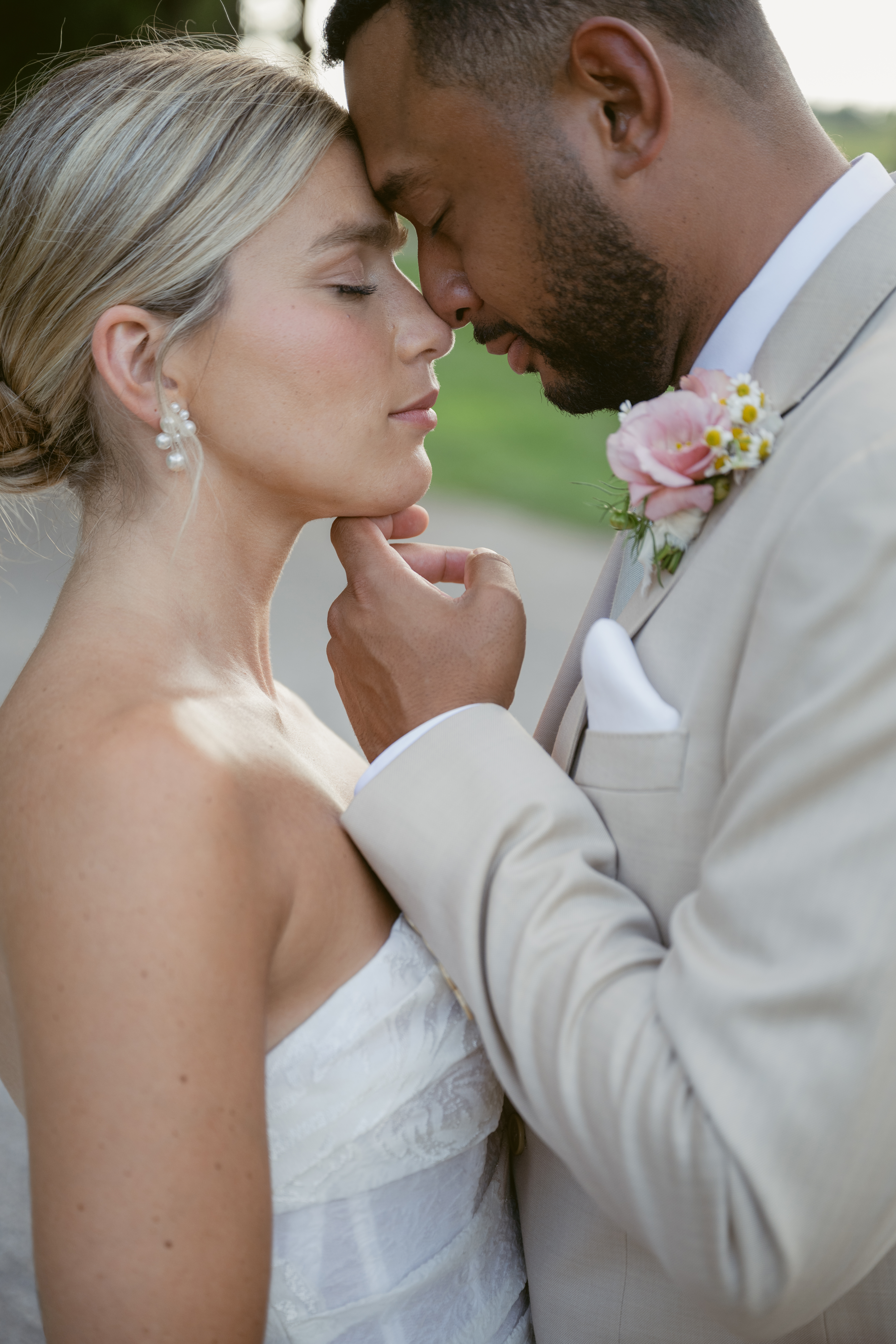 close up of a bride and groom, groom gentle lifting his wife's chin with their noses pressed together