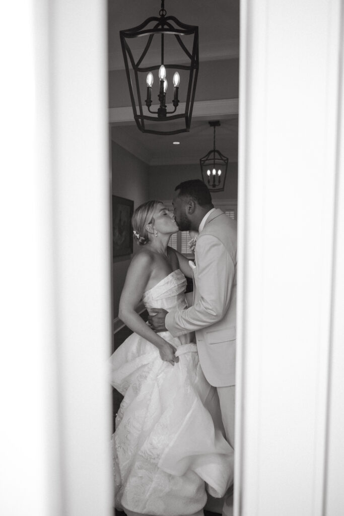 black and white photo of a groom and bride kissing