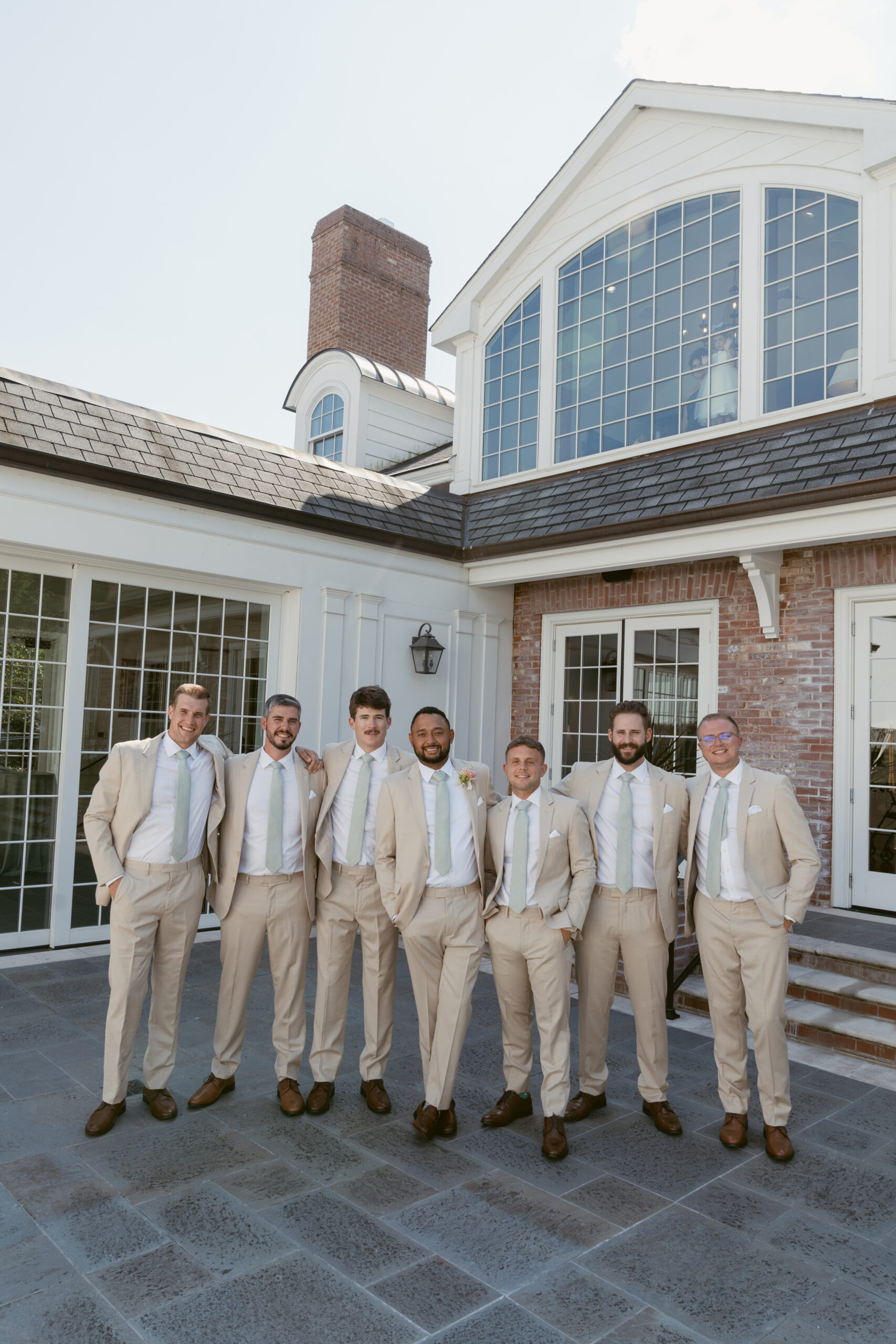 groom standing with his groomsmen dressed in beige suits - Wedding at Meshewa House
