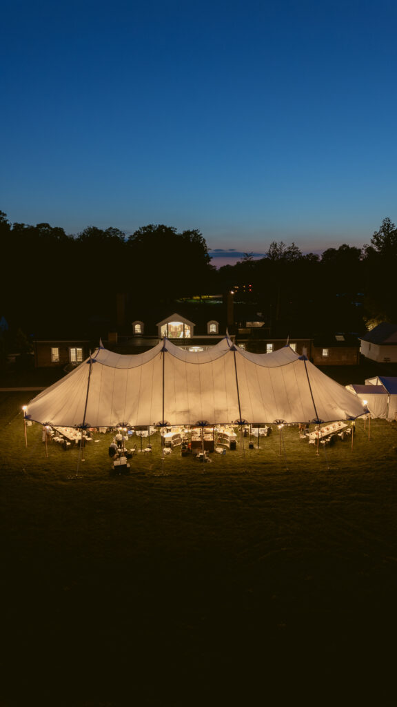 Glowing sailcloth wedding tent illuminated at dusk with twinkle lights and elegant decor—a Wedding at Meshewa House
