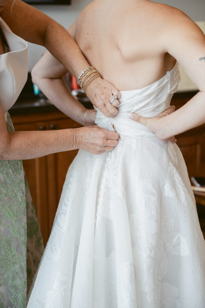 Mother helping bride into her wedding gown- Wedding at Meshewa House