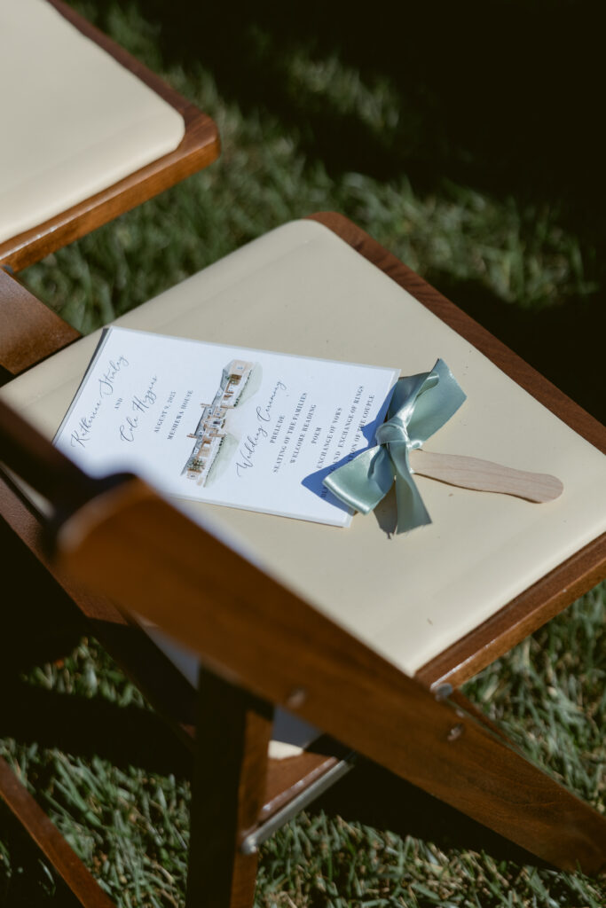 Ceremony program with watercolor venue illustration and ribbon fan - Wedding at Meshewa House