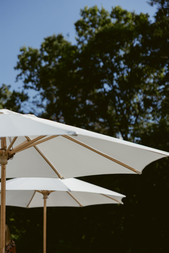 umbrellas over the chairs at a garden wedding ceremony