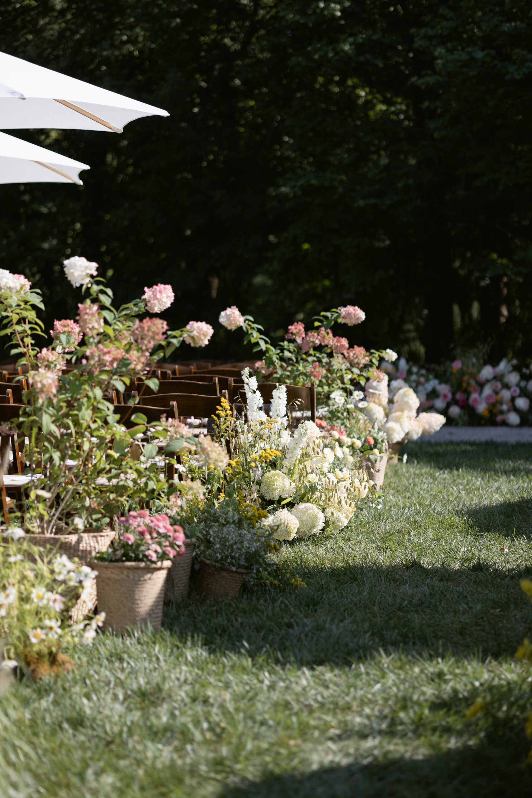 Lush ceremony florals in woven baskets line the aisle, Wedding at Meshewa House
