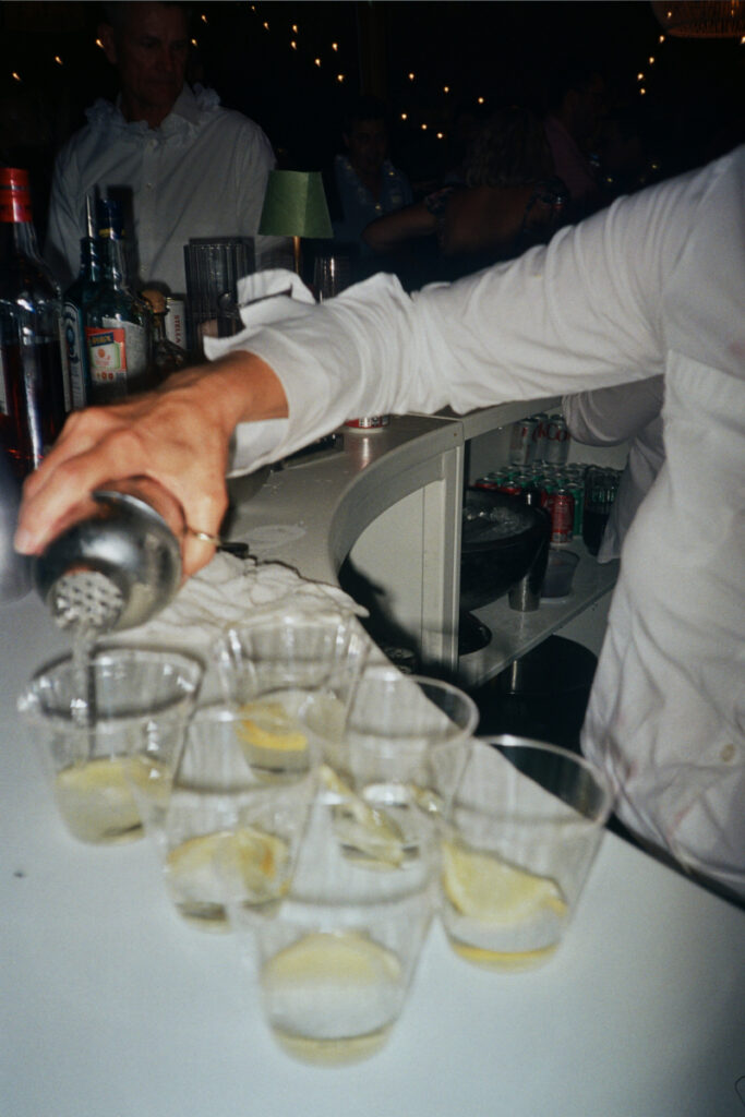 Bartender pouring cocktails at a wedding reception, capturing a lively moment while designing guest experience.