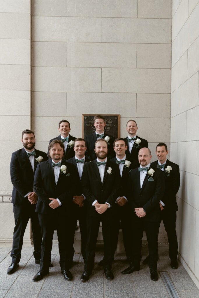 Groom standing with his groomsmen in tuxedos outside the museum during a Downtown Cincinnati Wedding.
