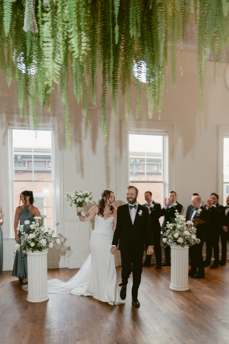 Newlyweds walk back down the aisle smiling after their Downtown Cincinnati Wedding ceremony at The Alcove.