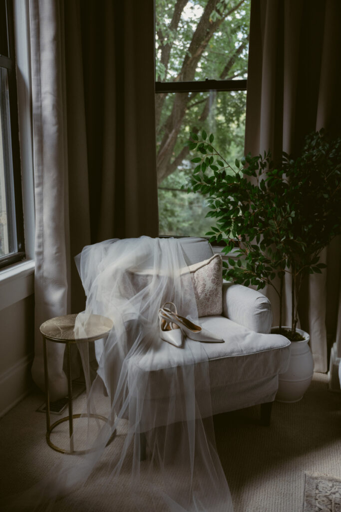Bridal shoes and veil draped over a chair during getting ready for a Downtown Cincinnati Wedding.