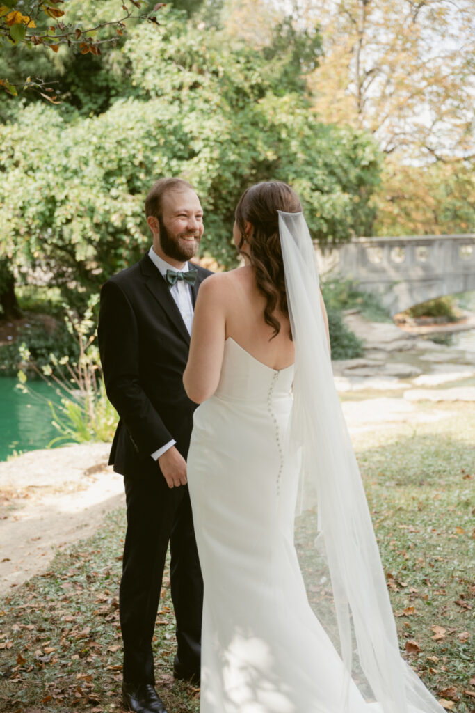 Bride and groom holding hands and smiling during their Downtown Cincinnati Wedding first look.