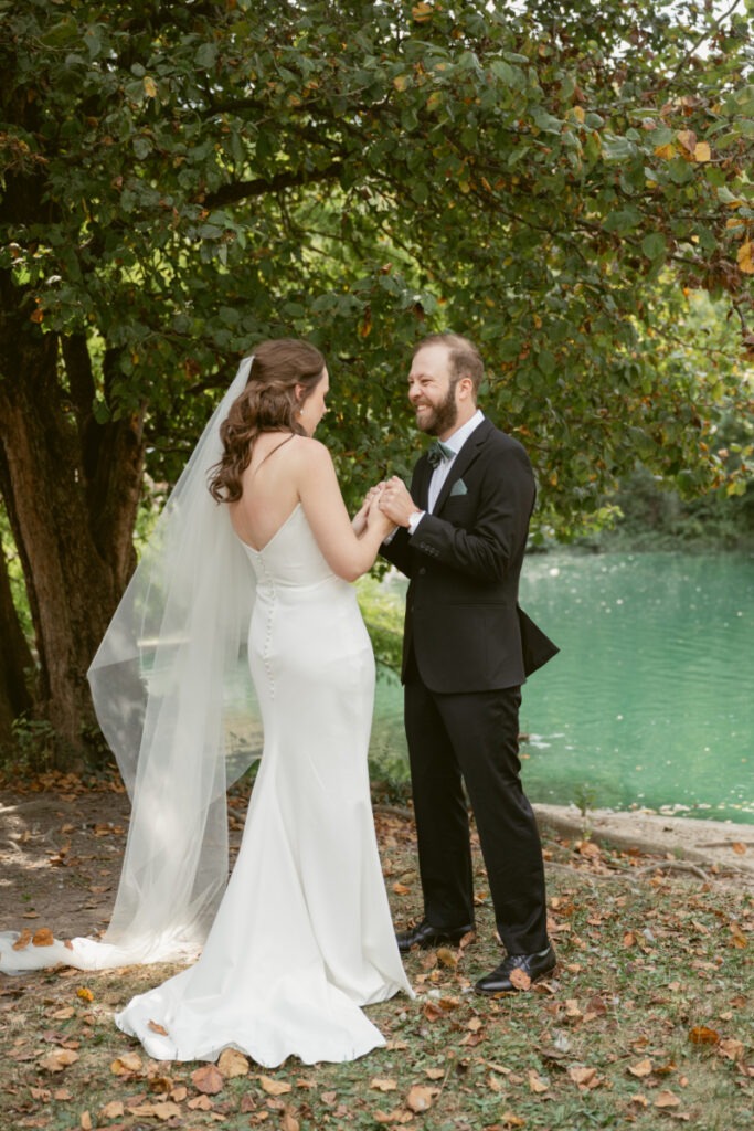 Bride and groom holding hands and smiling during their Downtown Cincinnati Wedding first look.