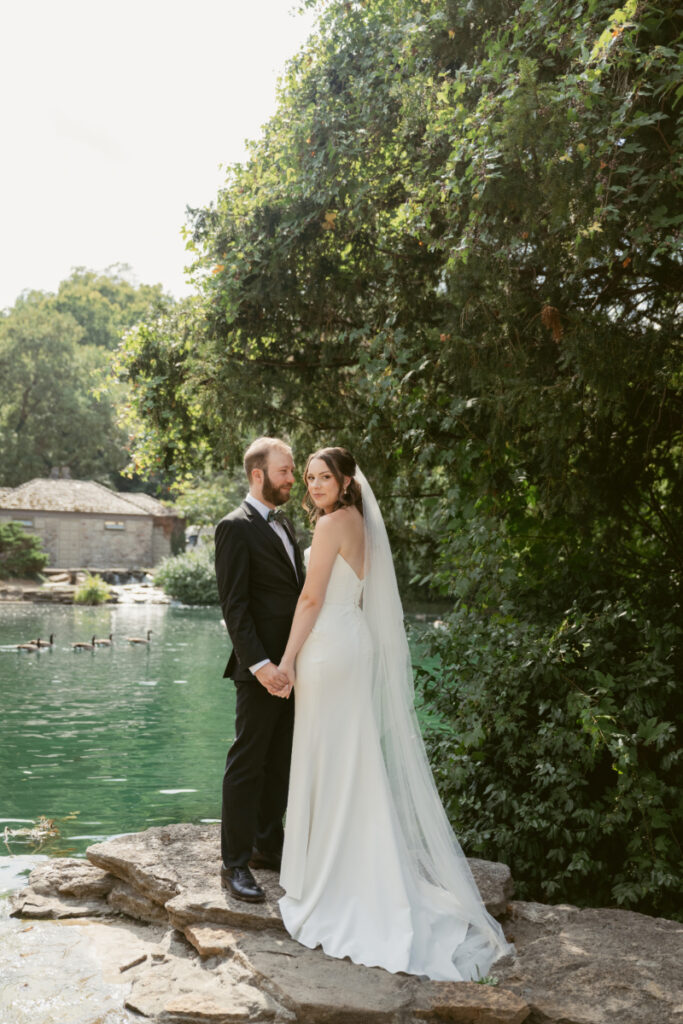 Bride and groom holding hands by the water during their Downtown Cincinnati Wedding at Eden Park.