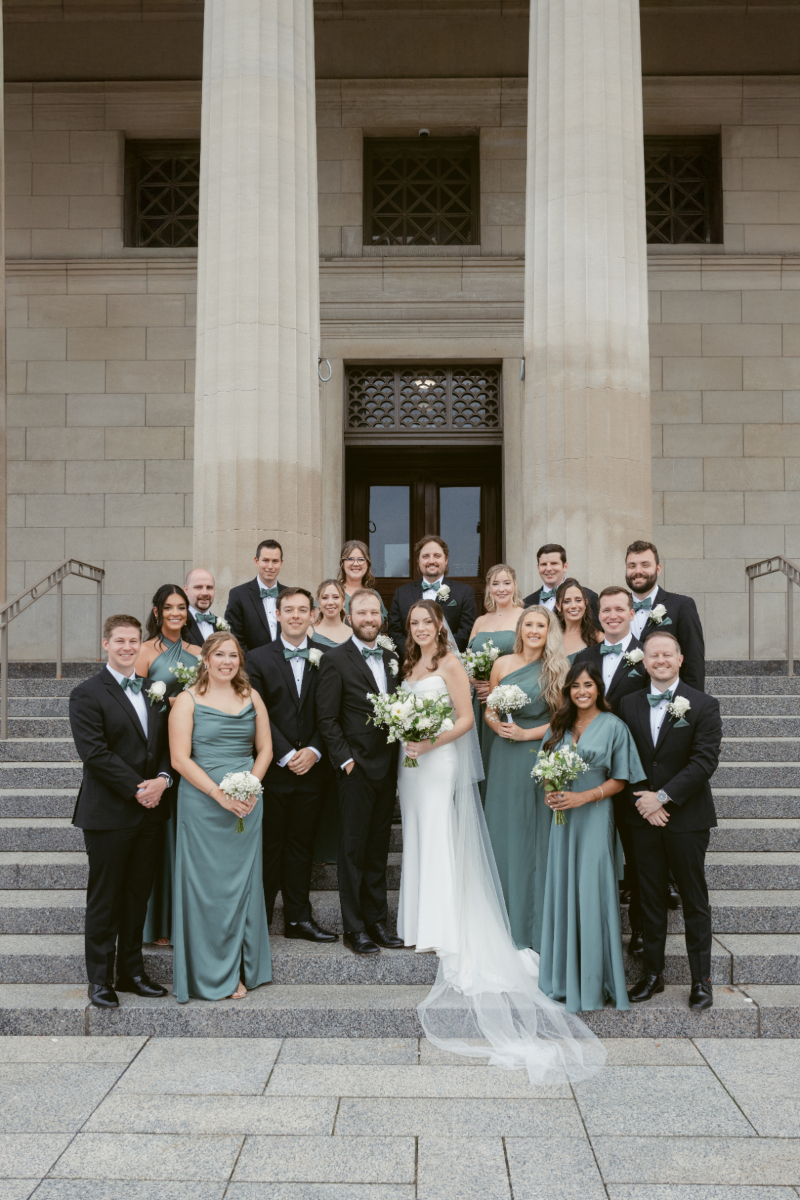 Full wedding party posed on museum steps during a Downtown Cincinnati Wedding celebration.
