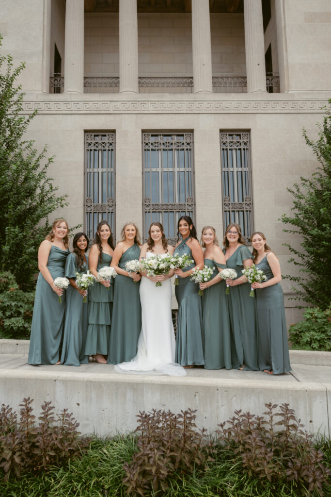 Bride standing with her bridesmaids in sage green dresses during a Downtown Cincinnati Wedding.