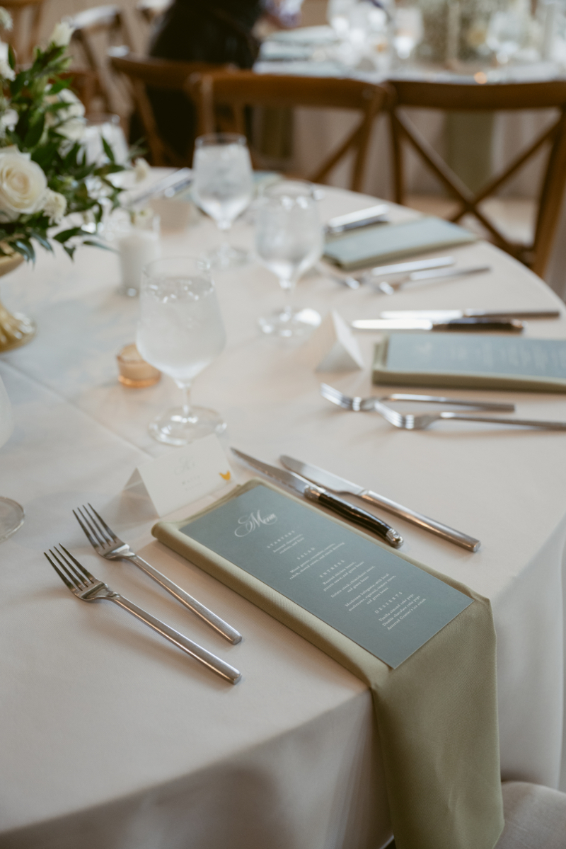 Elegant reception table setting with sage green napkins and menus at a Downtown Cincinnati Wedding.